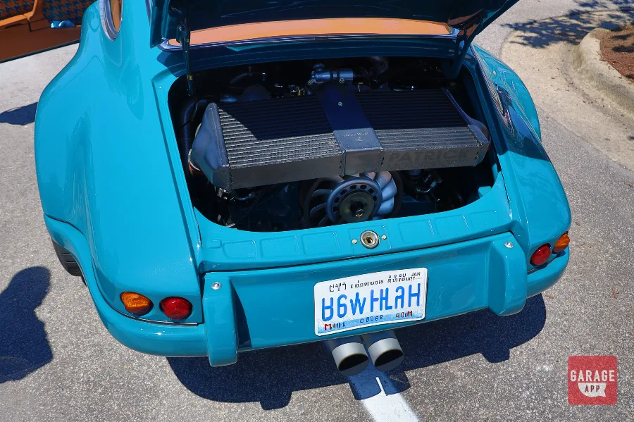 Rear view of a Singer Porsche 911 restomod showcasing dual exhaust outlets and carbon fiber body panels.