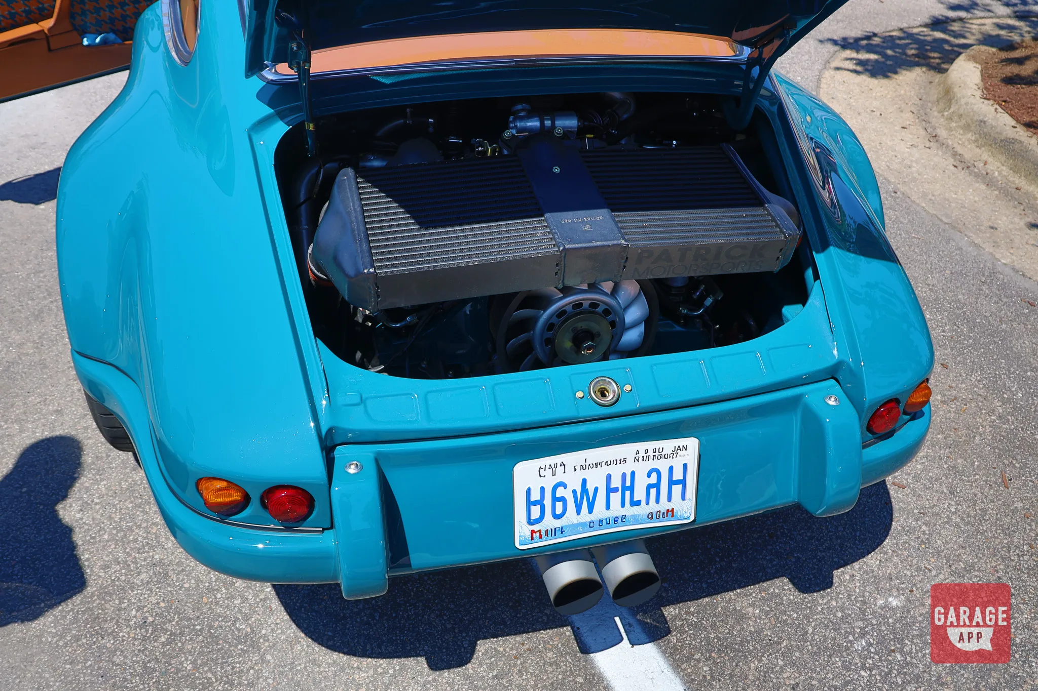 Rear view of a Singer Porsche 911 restomod showcasing dual exhaust outlets and carbon fiber body panels.