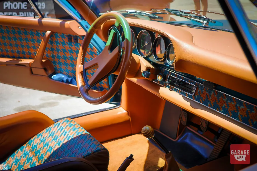 Interior of a Singer Porsche 911 featuring hand-stitched leather, custom gauges, and a driver-focused cockpit inspired by classic air-cooled Porsche design.