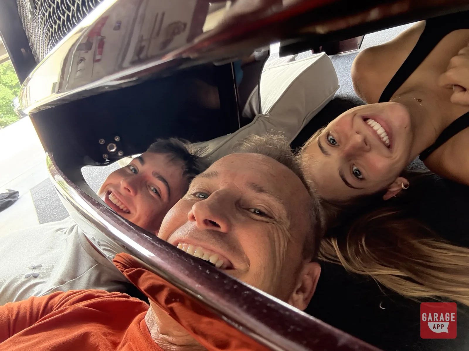 Dave and kids laughing while working on the Spyker