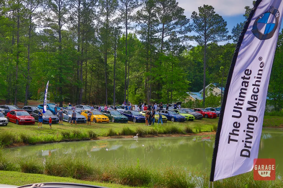 BMW enthusiasts displaying classic and modern BMW models during a community car show celebrating the brand's heritage.