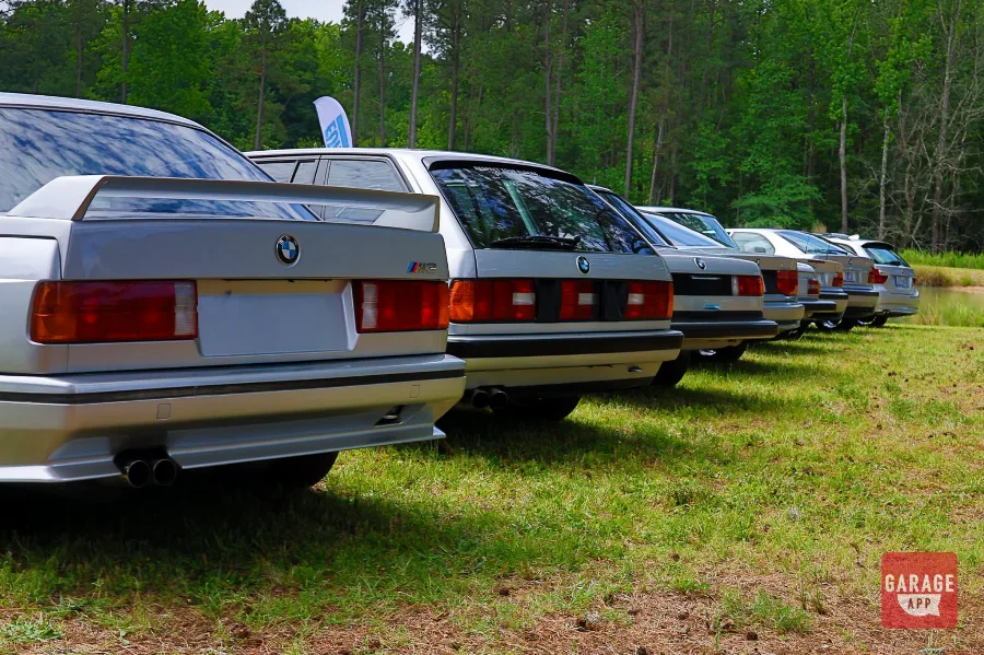 Rear view of a BMW E30 M3 and classic BMW lineup at Silver Horse Garage.