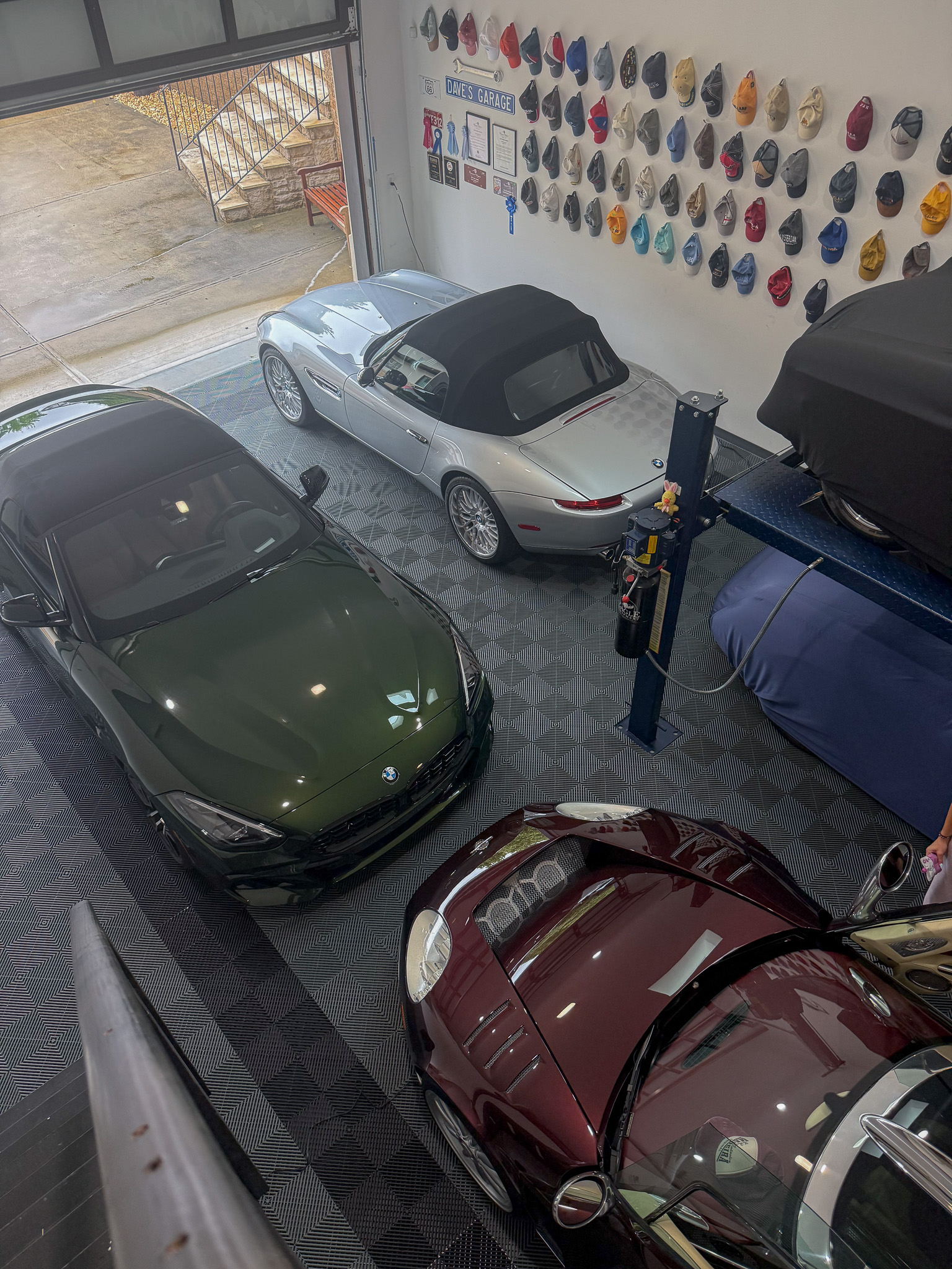 Silver BMW Z8, green Z4, and burgundy classic parked in private collector garage