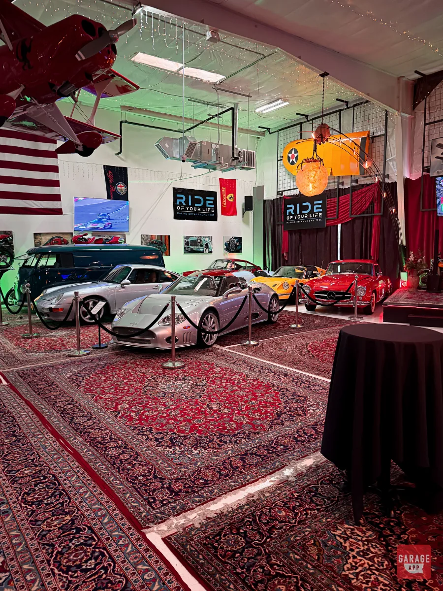 Classic Mercedes 300SL, silver Porsche 993, and VW bus displayed at car collection event