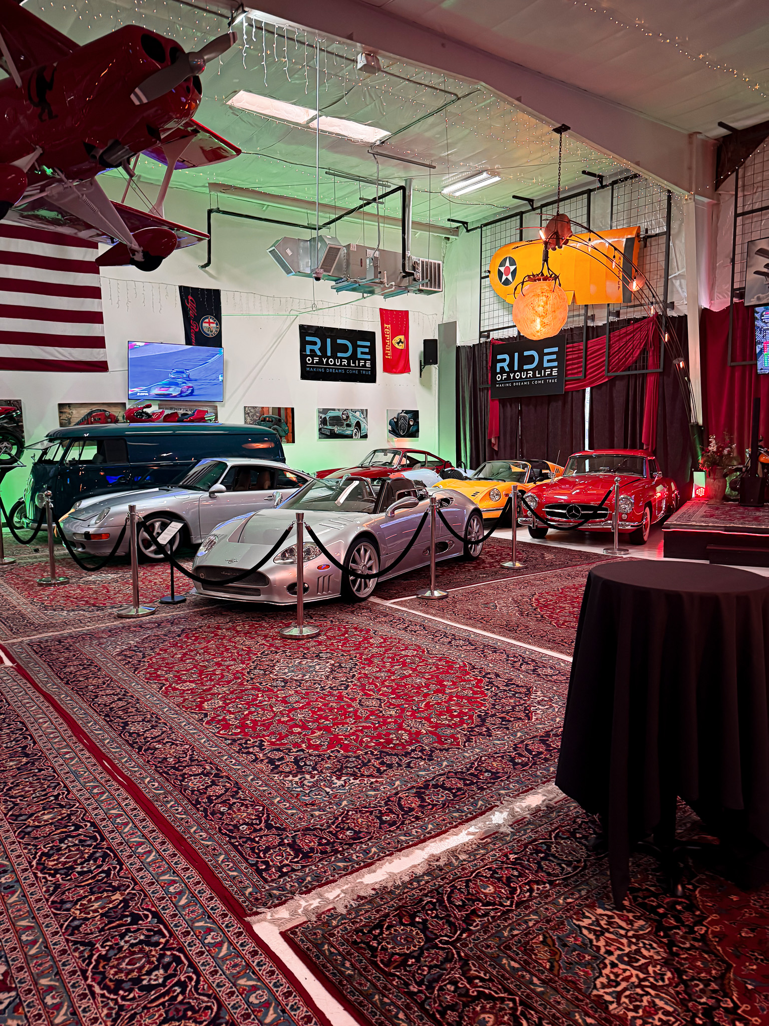 Classic Mercedes 300SL, silver Porsche 993, and VW bus displayed at car collection event