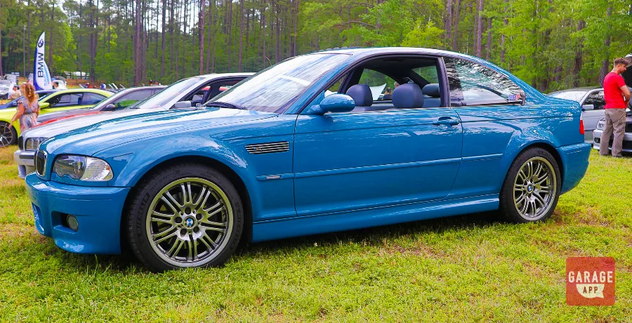 Front three-quarter view of a 2005 BMW E46 M3 in Laguna Seca Blue showcasing its iconic styling and widebody fenders.