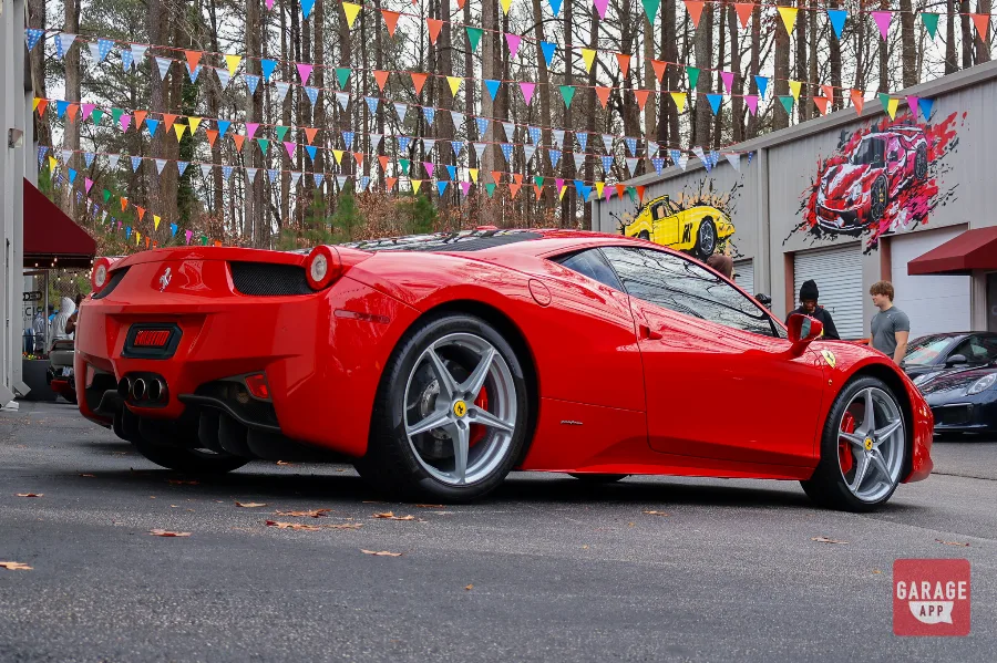 Red Ferrari 458 Italia rear quarter view under car show bunting