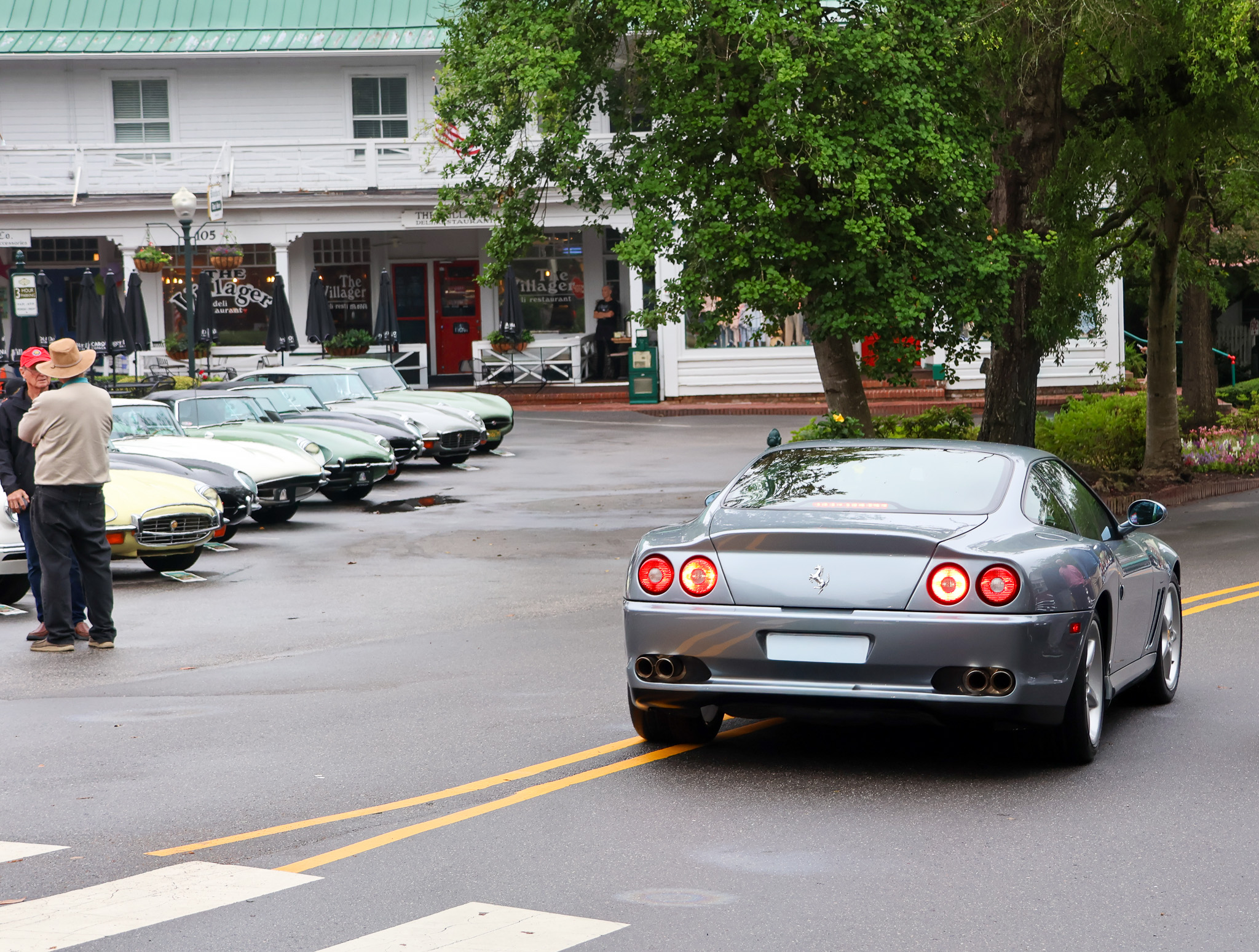 Silver Ferrari 550 Maranello rear view passing Jaguar E-Type lineup Pinehurst
