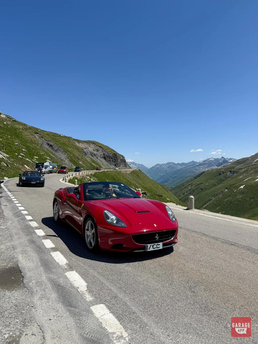 Red Ferrari California convertible Swiss Alps mountain pass