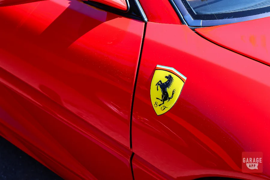 Close-up of the Ferrari prancing horse shield badge on a red Ferrari F355.