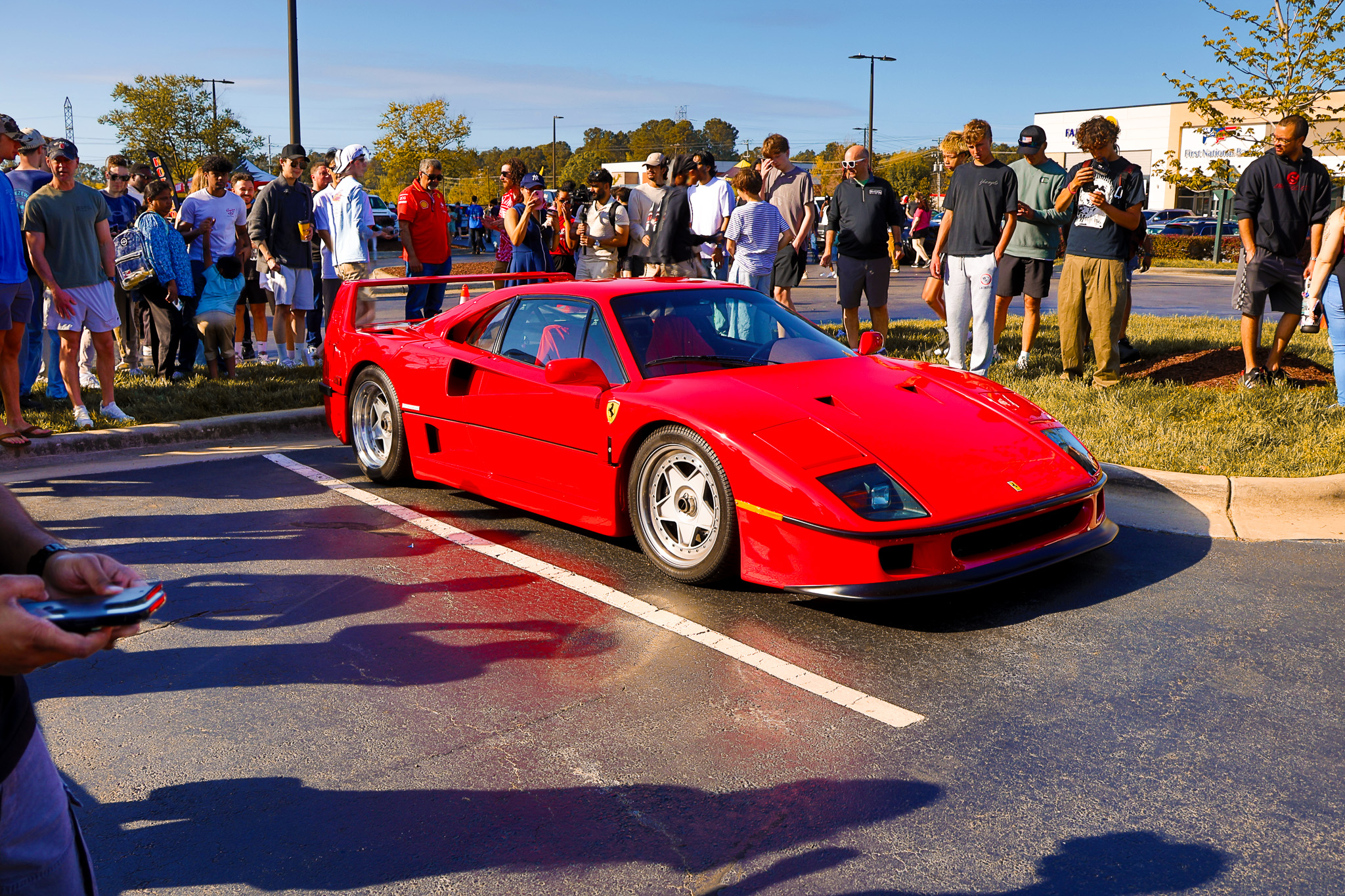 Red Ferrari F40 front three-quarter view at car show with crowd