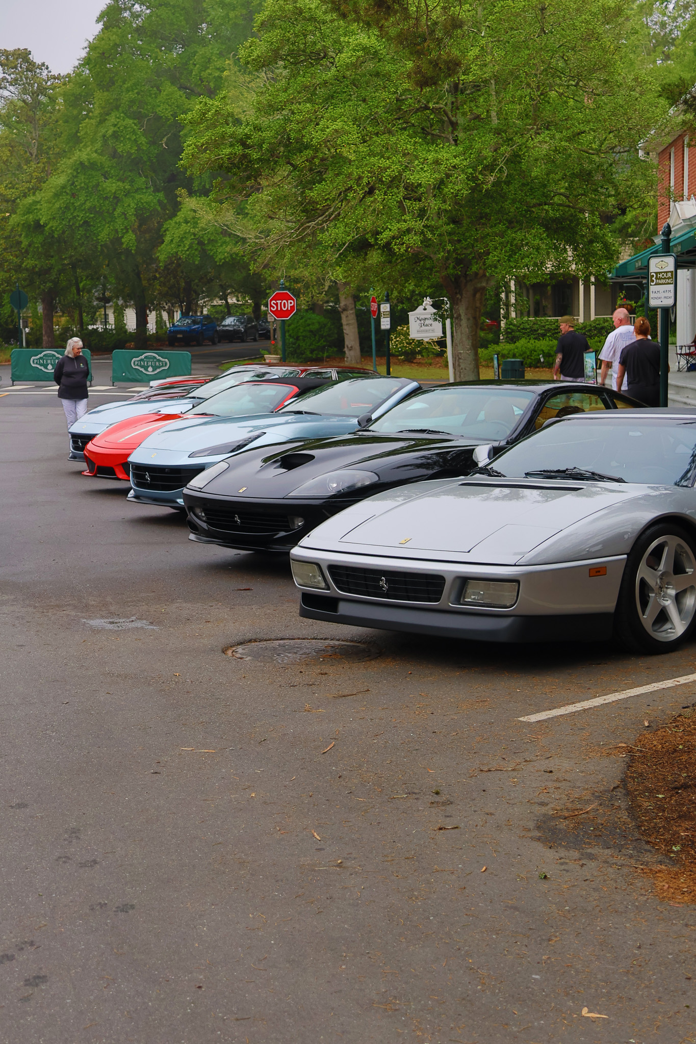 Row of classic Ferraris including Testarossa and F355 lined up at Pinehurst Village car show