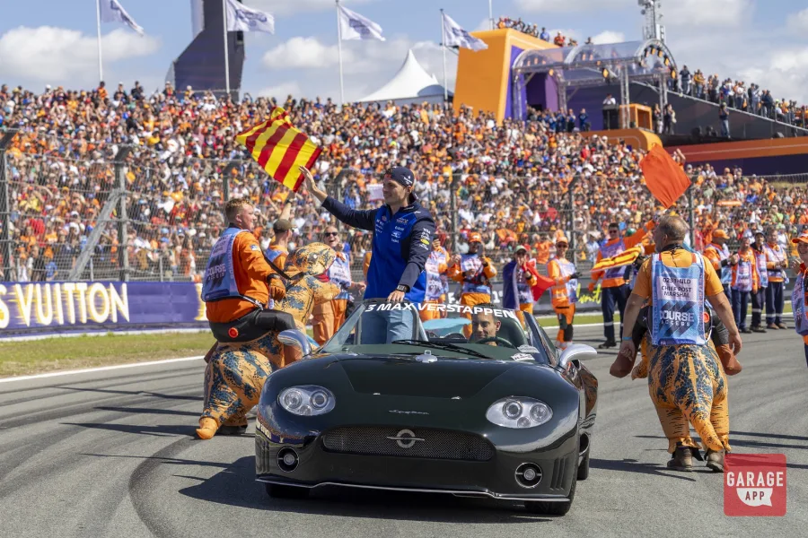 Max Verstappen standing in dark green Spyker C8 before home crowd at Zandvoort F1 Drivers' Parade