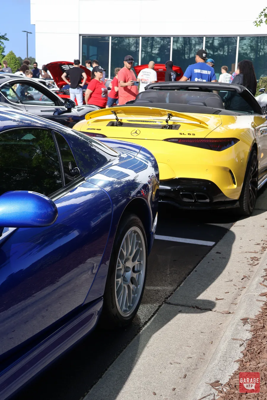 Yellow Mercedes-AMG SL63 rear view next to blue Dodge Viper