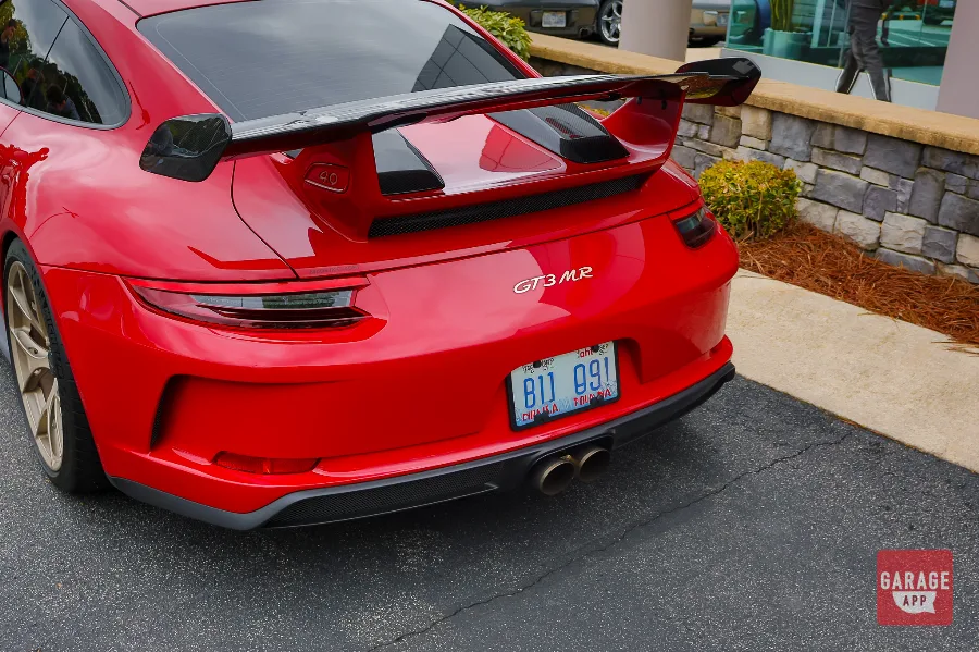 Rear view of a Guards Red Porsche 911 GT3 MR featuring the carbon fiber rear wing, center-exit exhaust, and Manthey Racing GT3 MR badging.