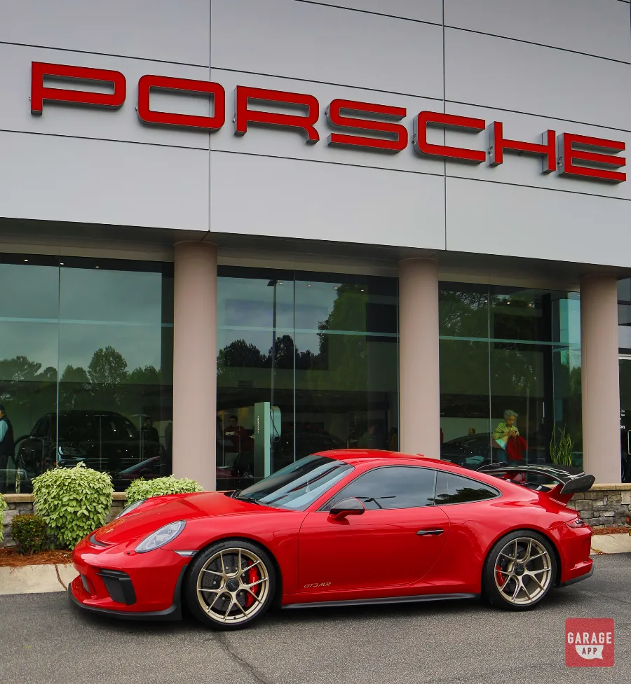 Porsche 991.2 GT3 MR parked outside a Porsche dealership, highlighting its complete side profile, carbon ceramic brakes, and Manthey Racing performance enhancements.