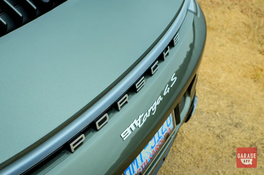 Close-up of the rear Porsche lettering on a 992.1 Porsche 911 Targa 4S finished in Aventurine Green Metallic, highlighting the full-width LED light bar.
