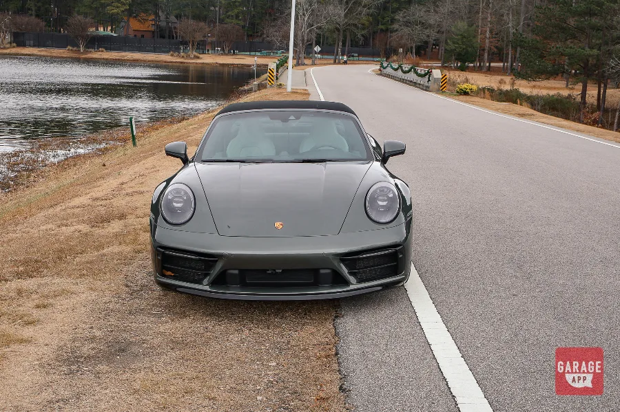Front view of a 992.1 Porsche 911 Targa 4S in Aventurine Green Metallic featuring Porsche LED headlights and a wide front fascia.