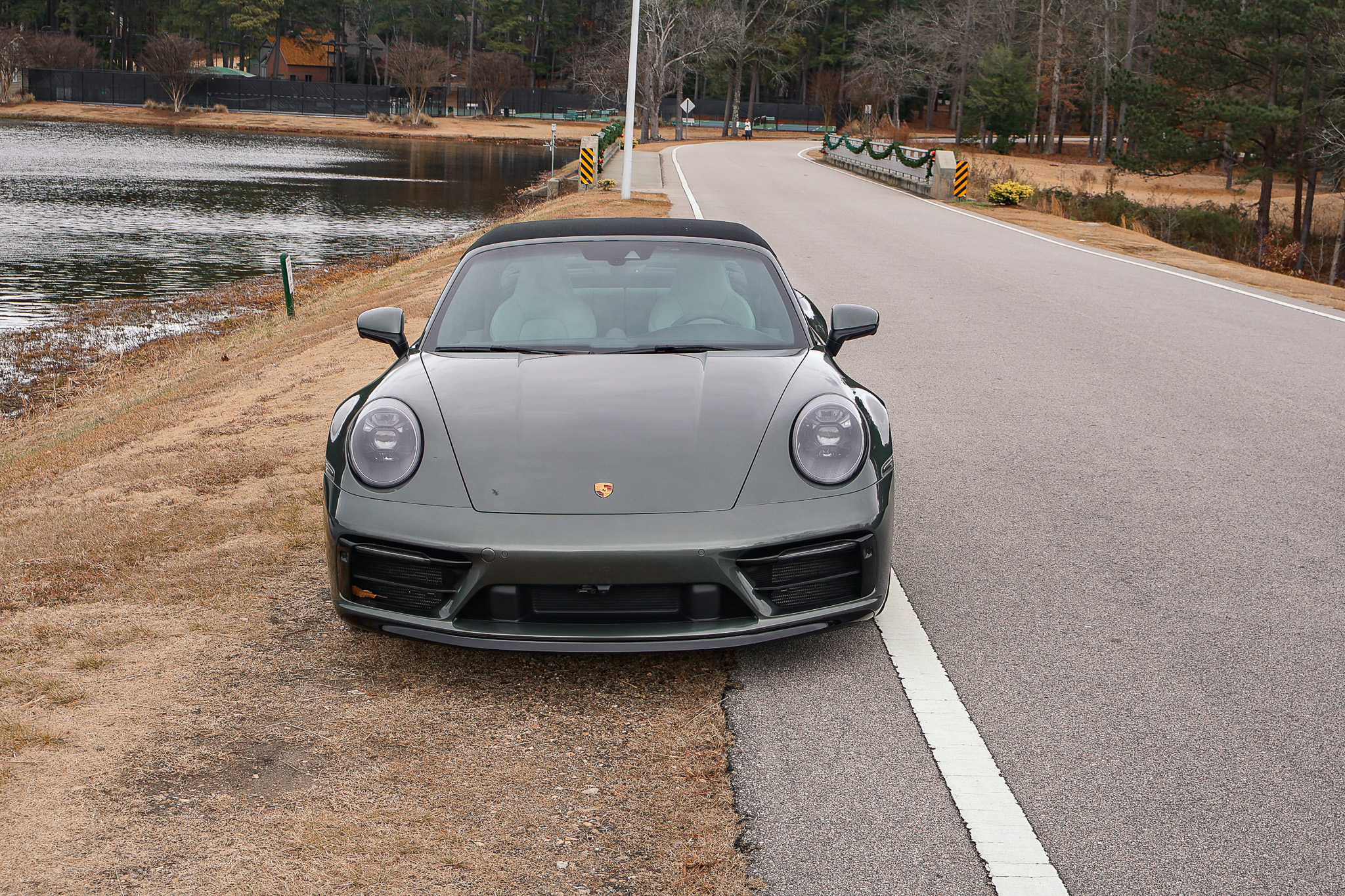 Front view of a 992.1 Porsche 911 Targa 4S in Aventurine Green Metallic featuring Porsche LED headlights and a wide front fascia.