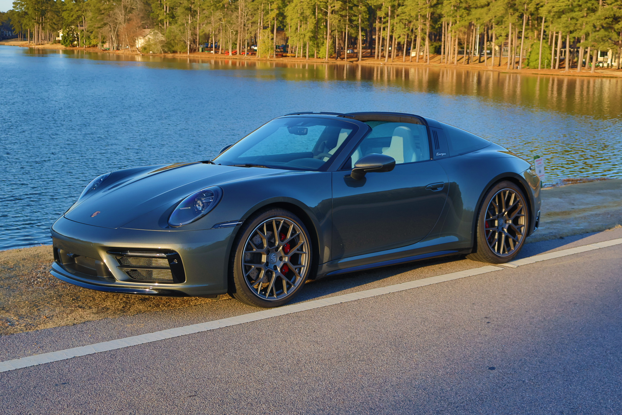 Front three-quarter view of a 992.1 Porsche 911 Targa 4S finished in Adventurine Green Metallic with the signature Targa roof and red brake calipers.