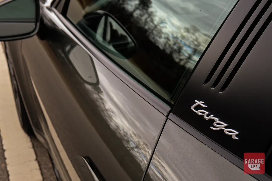 Close-up of the Targa script on the brushed roll bar of a 992.1 Porsche 911 Targa 4S finished in Aventurine Green Metallic.