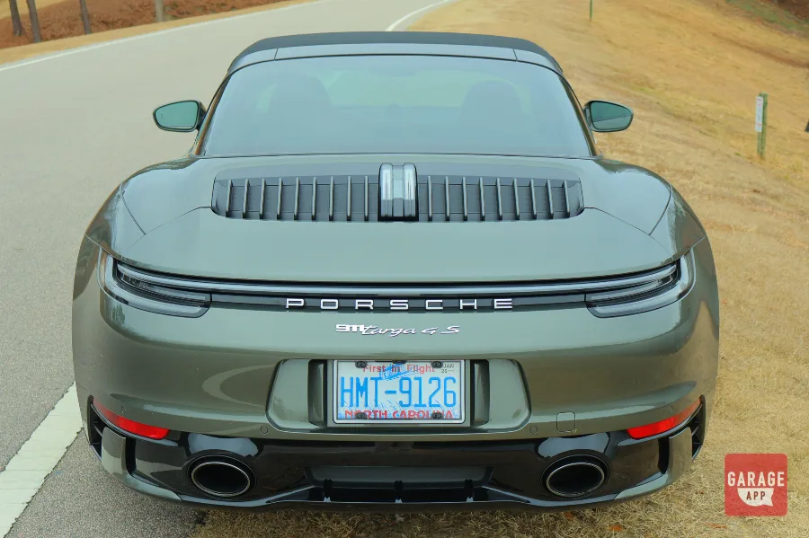 High rear view of a 992.1 Porsche 911 Targa 4S finished in Aventurine Green Metallic showcasing the rear engine cover and Porsche lettering.