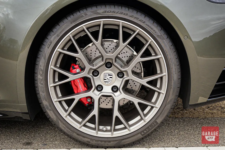 Close-up of the factory Porsche wheel on a 992.1 Porsche 911 Targa 4S finished in Aventurine Green Metallic, showcasing the performance brake system and timeless five-spoke wheel design.