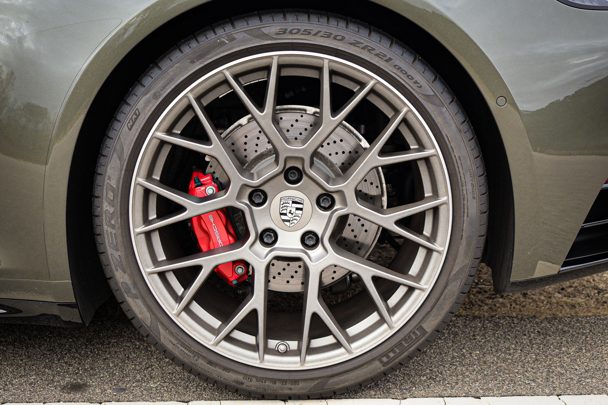Close-up of the factory Porsche wheel on a 992.1 Porsche 911 Targa 4S finished in Aventurine Green Metallic, showcasing the performance brake system and timeless five-spoke wheel design.