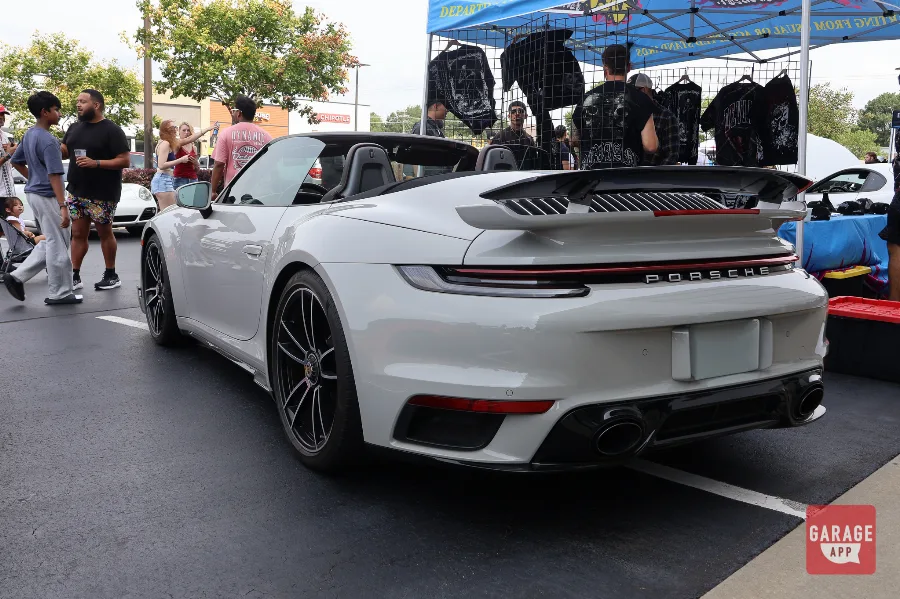 White Porsche 911 Turbo S Cabriolet rear quarter view at car meet with crowd