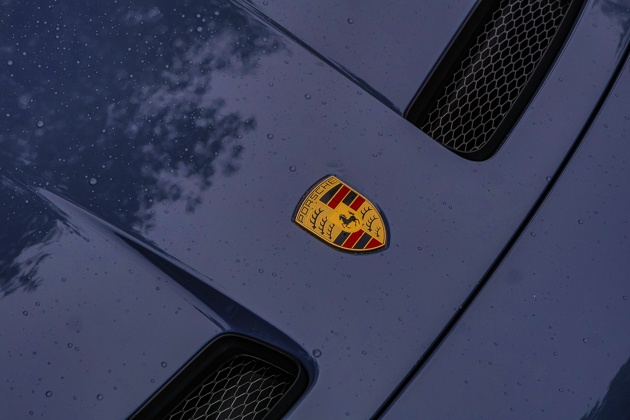 Porsche crest hood badge close-up on GT3 Touring in rain, raindrops on paint