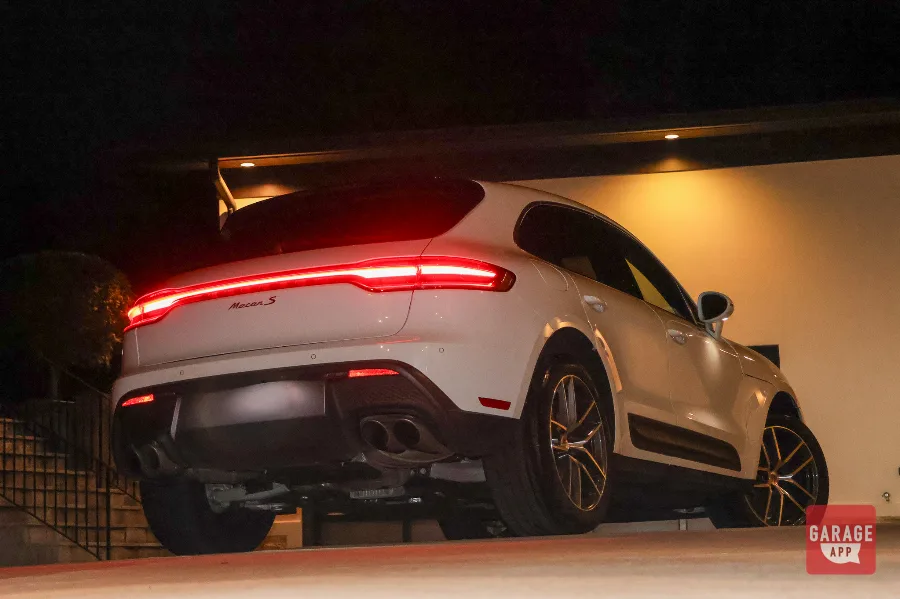 White Porsche Macan S rear three-quarter view at night with illuminated taillight and Macan S badge
