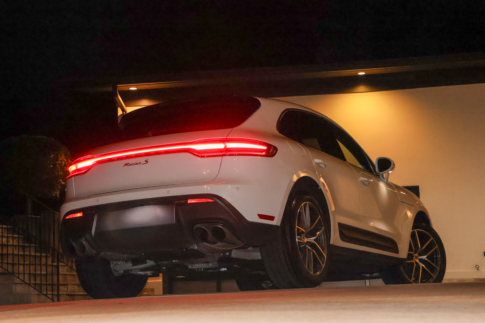 White Porsche Macan S rear three-quarter view at night with illuminated taillight and Macan S badge